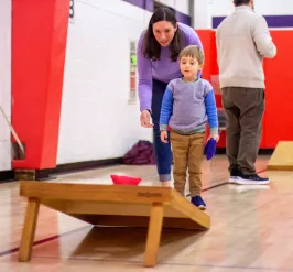 Mother and son playing cornhole during a family fun activity at the YMCA of Greater Brandywine.