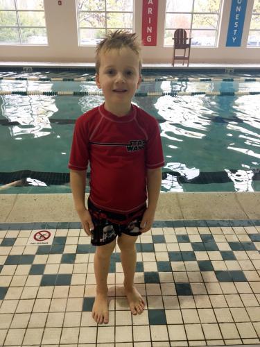 Dean, a young boy, poses at the indoor swimming pool at the West Chester Area YMCA where he learned how to swim. 
