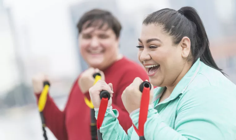 Woman Laughing while exercising with friend 