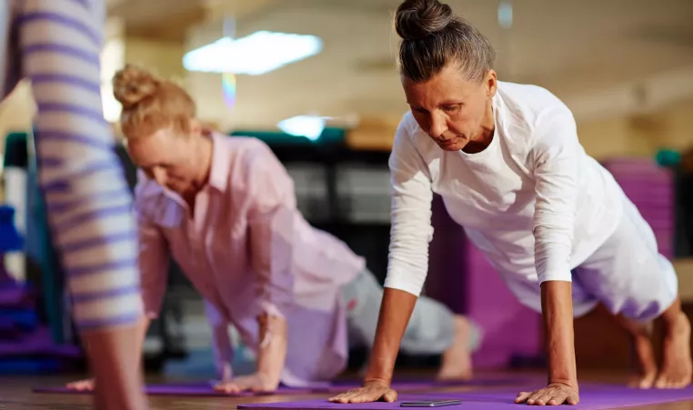 two women doing planks in an exercise class