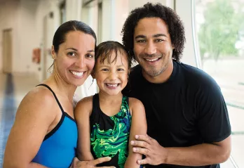 A family poses with their daughter after her swimming lessons at the YMCA indoor swimming pool in Chester County. 