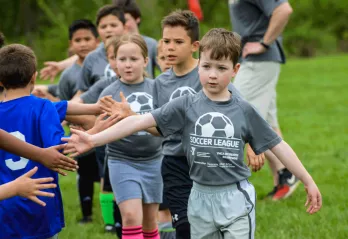 Youth Sports - A youth soccer team shakes hands at the end of their soccer game.