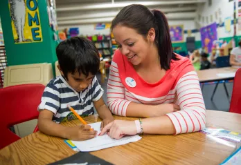 Kindergarten teacher helping a student with homework at the Oscar Lasko YMCA in West Chester, Pa