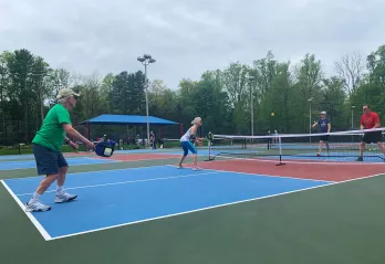 A group of Upper Main Line YMCA members play a game of pickleball on the new outdoor pickleball courts at the Berwyn location. 