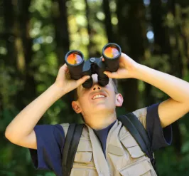 A boy uses binoculars to study birds during an environmental and nature program at the Upper Main Line YMCA in Berwyn, PA