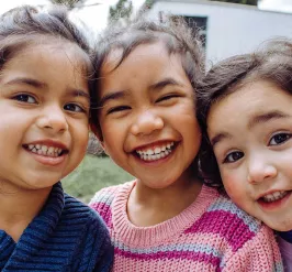 Three young girls smile at the camera 