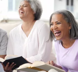 Group of  seniors laughing at book club 