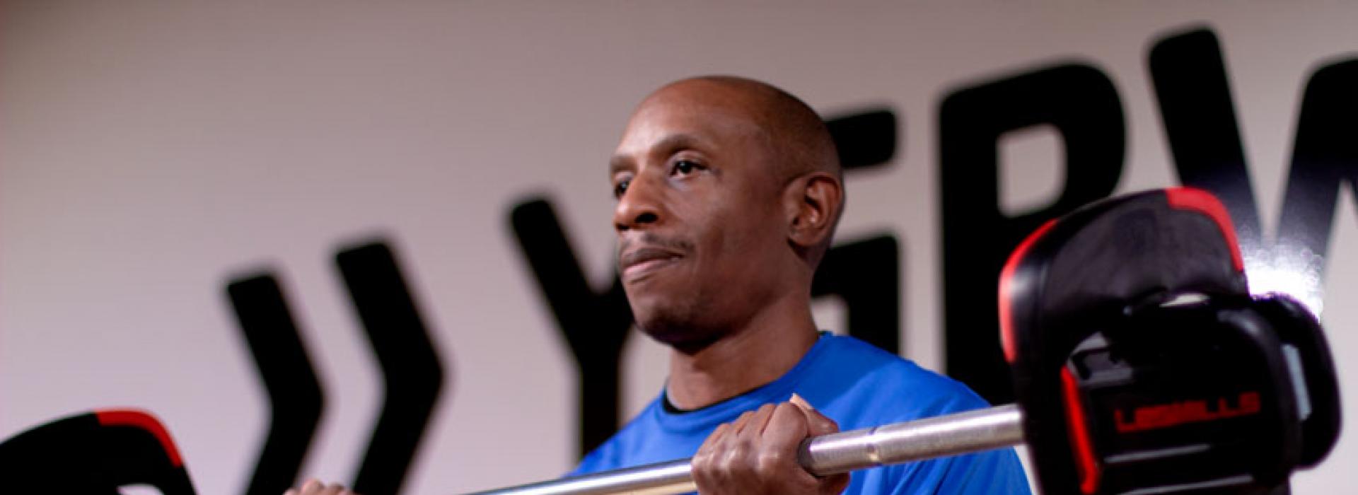 Personal trainer Kareem Lanier demonstrates proper form when lifting weights at the Kennett Area YMCA