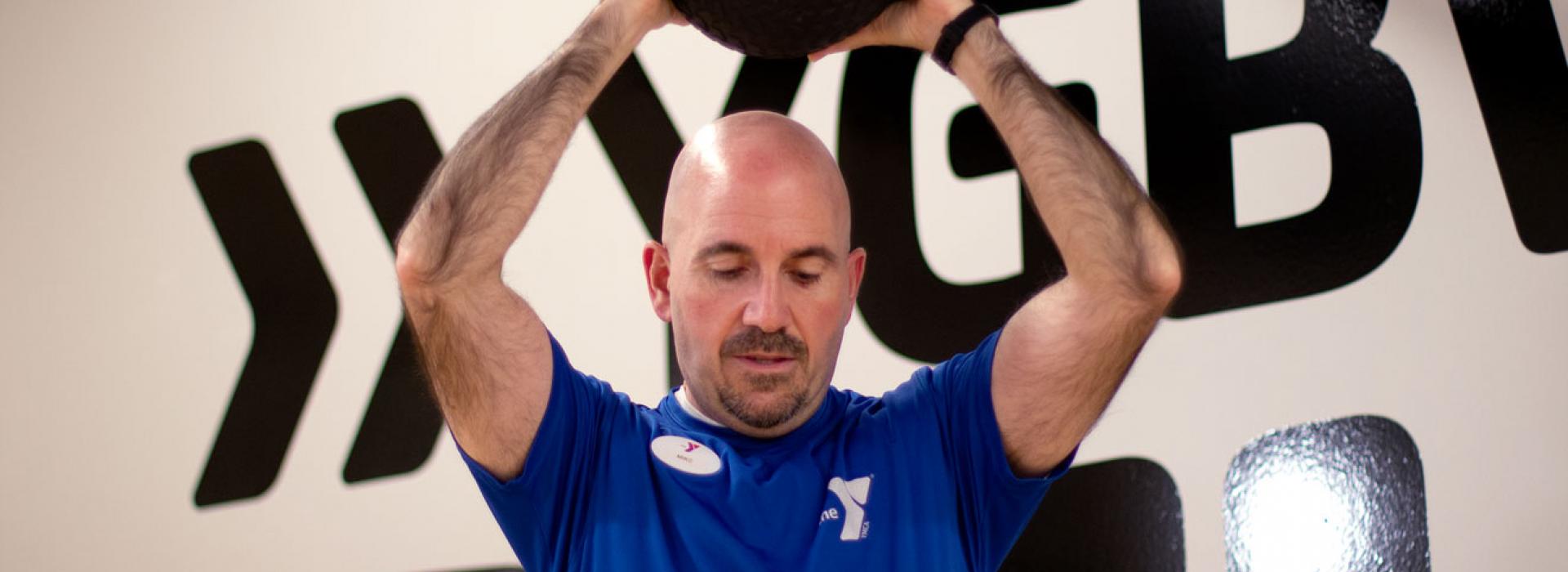 Kennett Area YMCA personal trainer Mike Lobiondo demonstrates an exercise using a weighted ball.