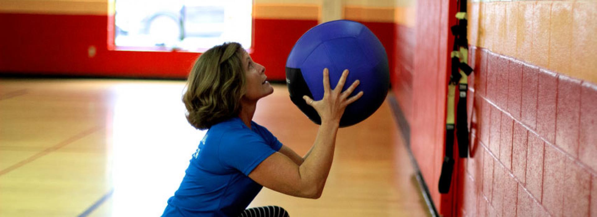Oscar Lasko YMCA personal trainer Wendy Young demonstrates a workout with a weighted ball in the gym at the Oscar Lasko YMCA in West Chester PA