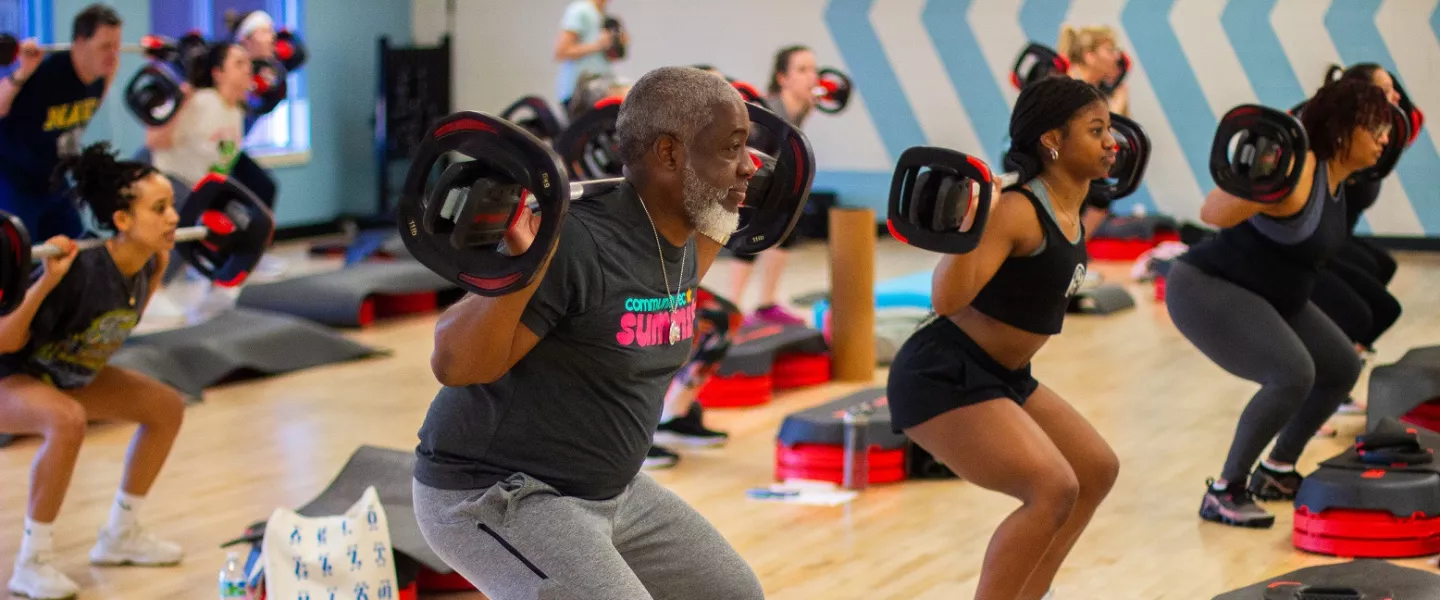 Family Lifts Barbell in BODYPUMP Class