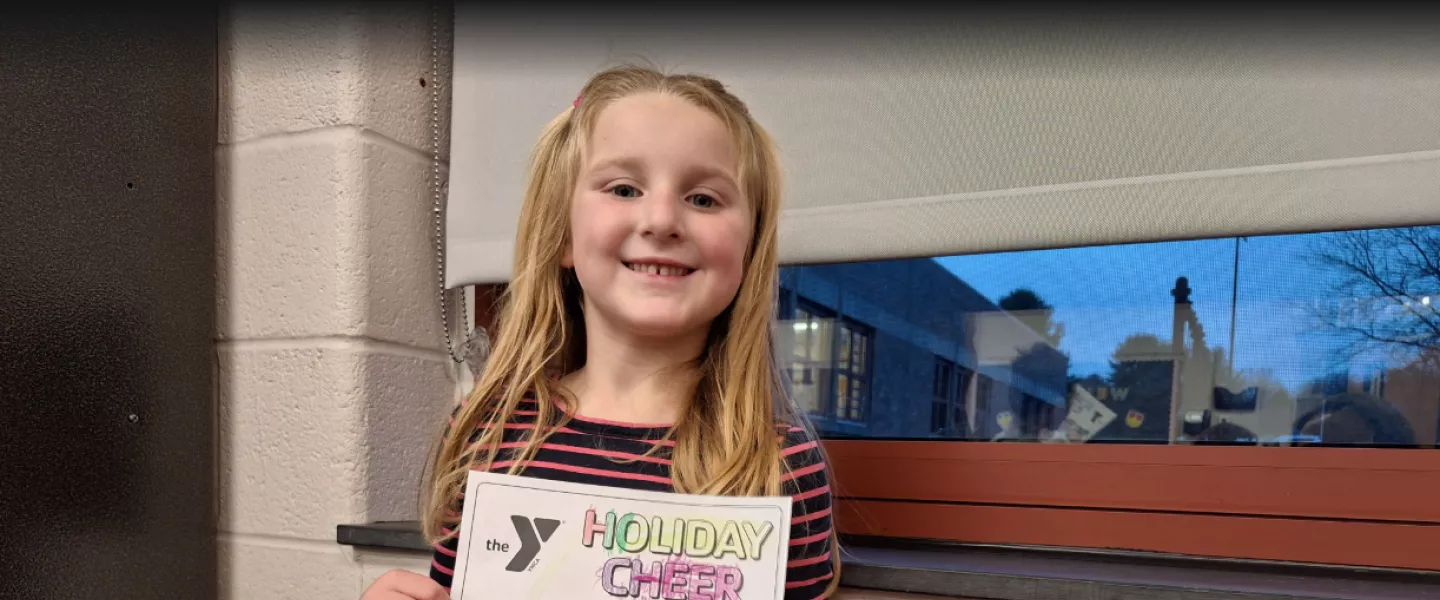 Young girl with Holiday Cheer coloring page at the YMCA of Greater Brandywine.