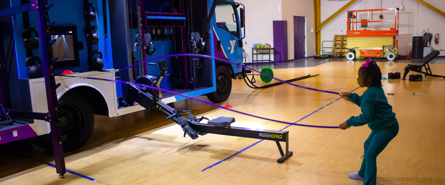 Young child using the ropes on the YMCA of Greater Brandywine mobile fitness truck, YGBW Fit Truk.