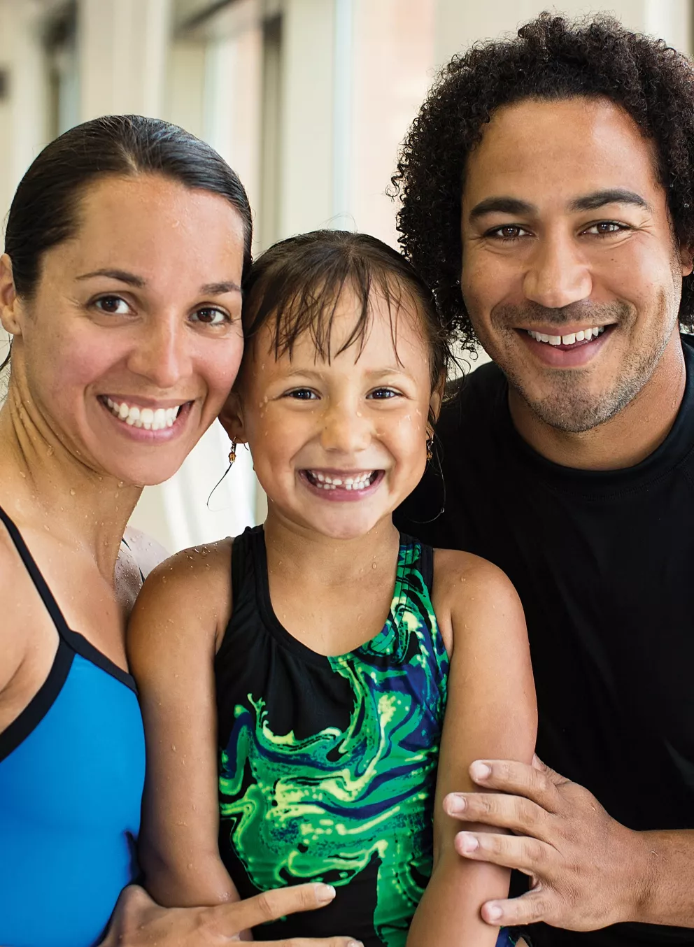 A family poses with their daughter after her swimming lessons at the YMCA indoor swimming pool in Chester County.