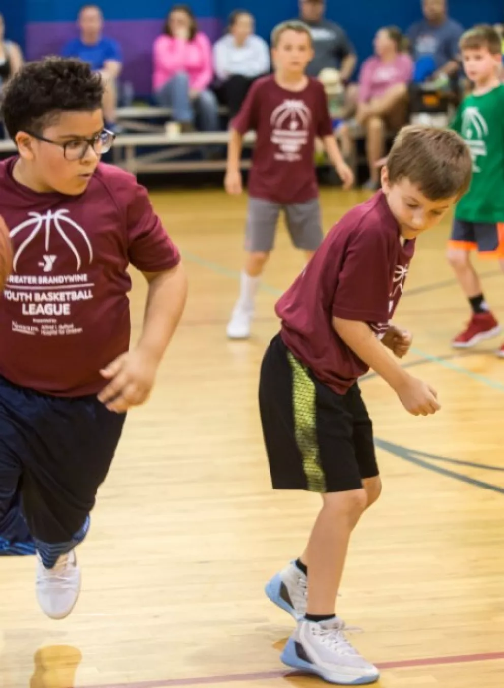 Youth basketball player dribbling a basketball during a YMCA youth sport league game.