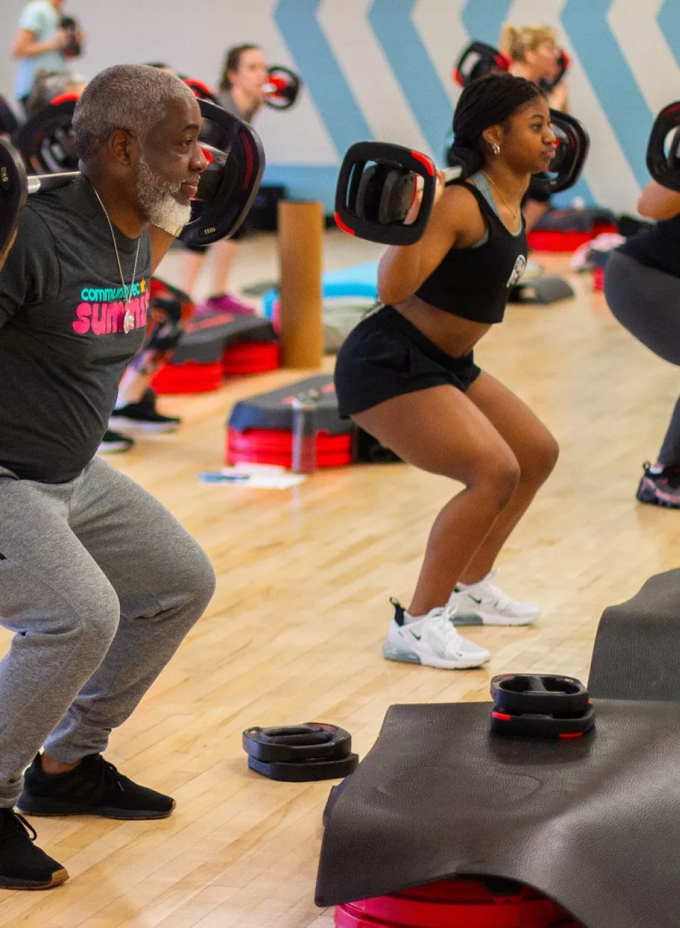 Family Lifts Barbell in BODYPUMP Class