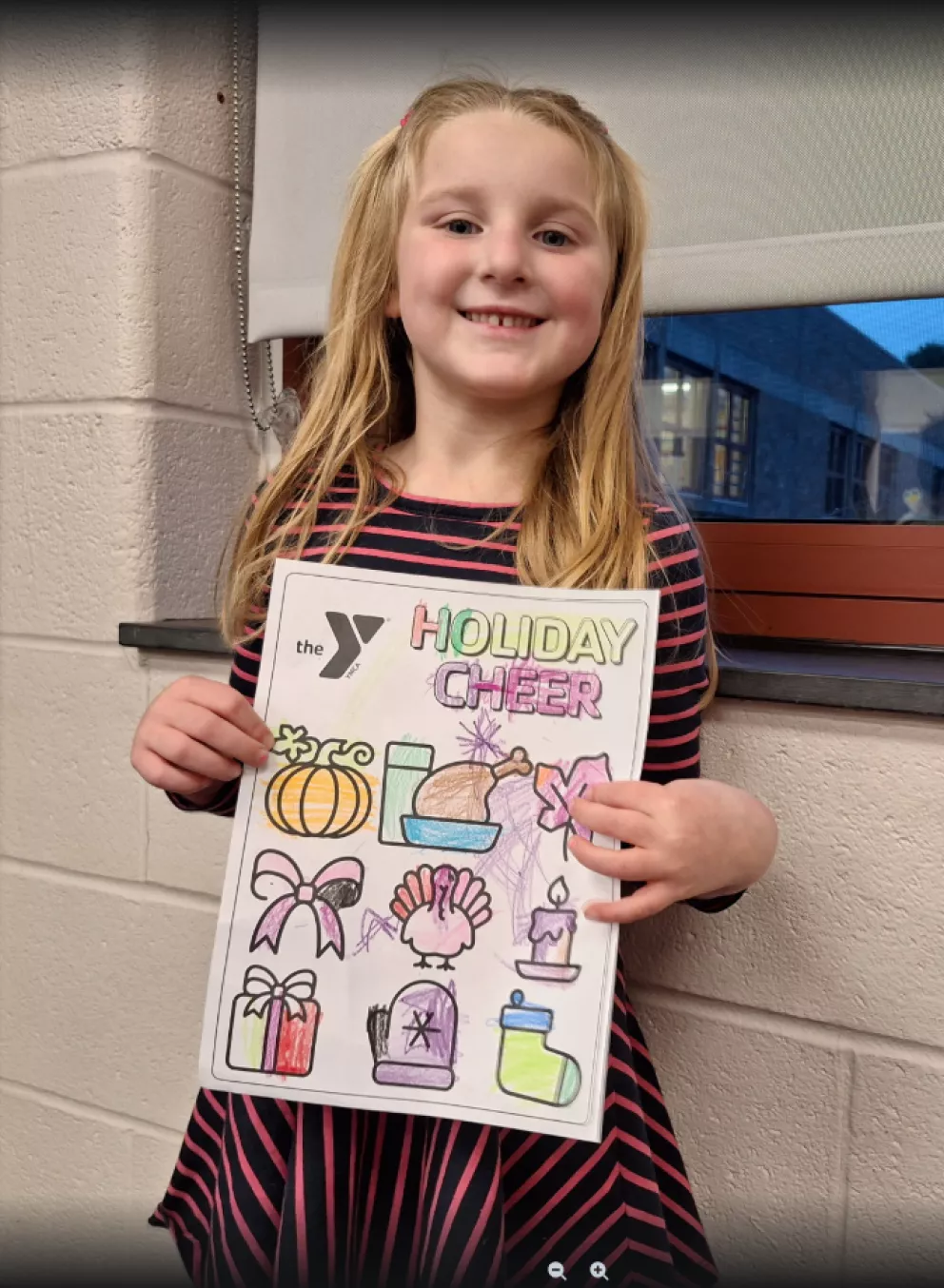 Young girl with Holiday Cheer coloring page at the YMCA of Greater Brandywine.