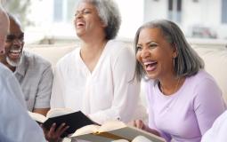 Group of  seniors laughing at book club 