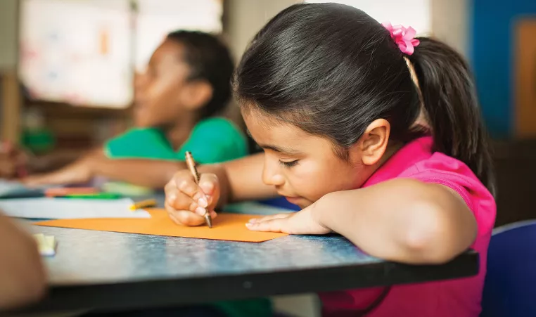 An elementary school student does her homework during the after school program at the YMCA.