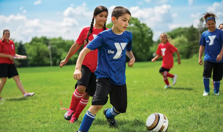 A boy and girl playing soccer in a YMCA youth sports soccer league in Chester County.