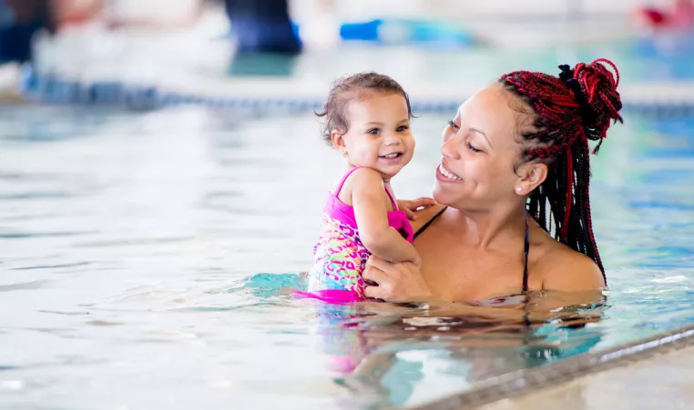 A mother and daughter participate in swimming lessons for toddlers at the indoor swimming pool in the YMCA in Chester County