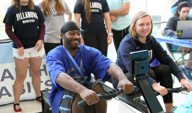 Young man and women test rowing exercise equipment at the YMCA. 