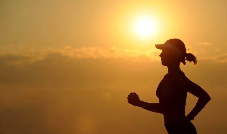 A woman running outside at sunrise