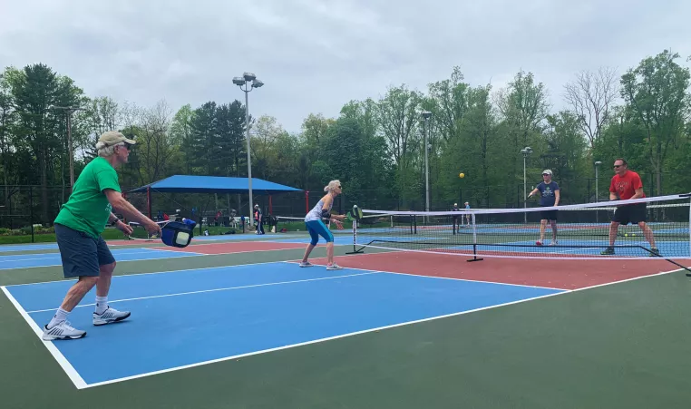 A group of Upper Main Line YMCA members play a game of pickleball on the new outdoor pickleball courts at the Berwyn location. 