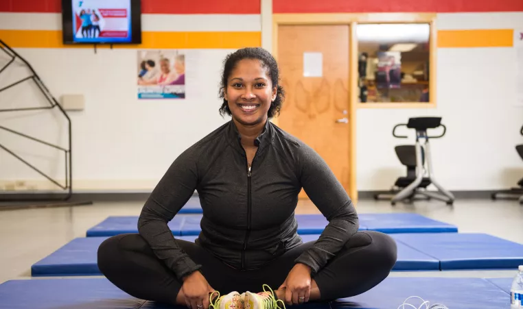 Yoga Instructor Sitting on Mat and Smiling