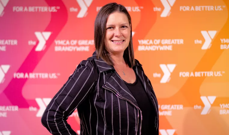 Photo of Jess Rigo, executive director of the Brandywine Y in front of Y background