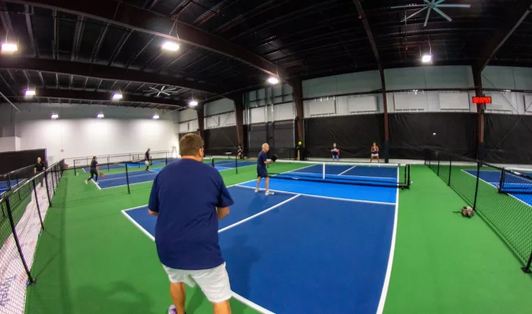 Several people play pickleball on the indoor pickleball courts at YMCA Pickleball Center in Downingtown