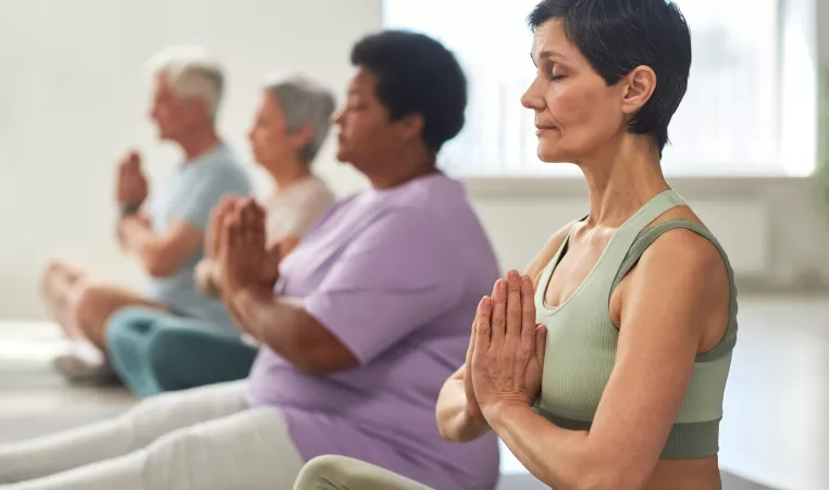 Seniors meditating in a group exercise studio