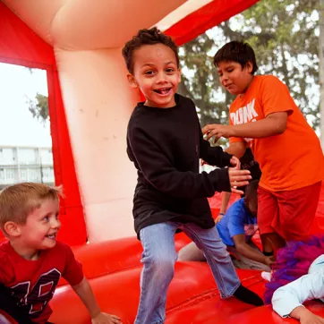 A group of kids play in a bounce house at a YMCA Healthy Kids Day event. 