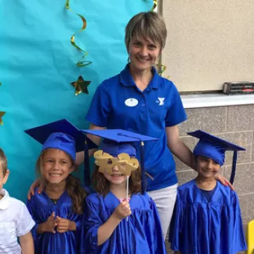Natalya Kuzovleva, a Montessori preschool program teacher, poses with children on their graduation from the Montessori program at the West Chester Area YMCA