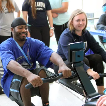 Young man and women test rowing exercise equipment at the YMCA. 