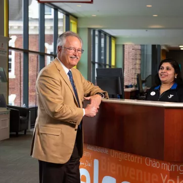 Bob Riggs poses in front of the welcome desk at Upper Main Line YMCA in Berwyn, PA