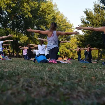 Individuals participate in an outdoor yoga class