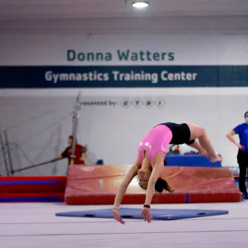 Gymnast doing a back handspring in the gymnastics center