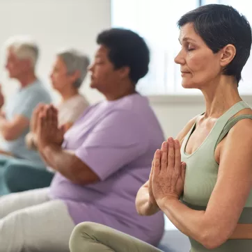 Seniors meditating in a group exercise studio
