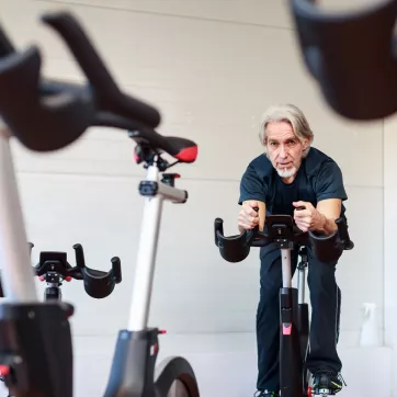 Senior man taking a cycling class at the Y