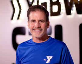 Personal trainer standing in front of a Y logo 