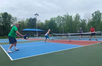 A group of Upper Main Line YMCA members play a game of pickleball on the new outdoor pickleball courts at the Berwyn location. 